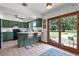 Functional kitchen with green cabinetry, an island with stools, and access to the backyard, perfect for indoor/outdoor living at 4055 State Road 11, Deland, FL 32724