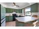 Charming kitchen featuring green cabinets, black appliances, and a breakfast bar with seating at 4055 State Road 11, Deland, FL 32724