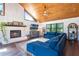 Cozy living room with fireplace, wood ceiling, and comfortable blue sectional sofa, creating a warm and inviting space at 4055 State Road 11, Deland, FL 32724