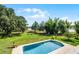 Backyard pool featuring green grass, lake view, mature trees and outdoor seating at 4055 State Road 11, Deland, FL 32724