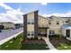 Modern townhome showcasing a two-story facade, landscaped yard, and convenient parking at 4184 Paragraph Dr, Kissimmee, FL 34746