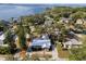 Aerial view showcasing the home with a metal roof, lush greenery, and a glimpse of the lake at 465 W Lakeshore Dr, Clermont, FL 34711