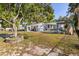 Wide view of the home's backyard featuring its detached garage and outdoor seating at 465 W Lakeshore Dr, Clermont, FL 34711
