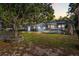 Spacious backyard with a pergola, brick barbeque, green grass, mature trees, and a shed at 465 W Lakeshore Dr, Clermont, FL 34711