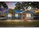 Charming single-story home featuring a blue metal roof, manicured landscaping, and a cozy front porch area at 465 W Lakeshore Dr, Clermont, FL 34711
