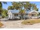 Charming home featuring lush landscaping, a metal roof, and mature trees at 465 W Lakeshore Dr, Clermont, FL 34711