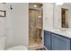 Bathroom showcases glass shower with marble tile, a sink with blue cabinets, and decorative hardware at 4756 Fiske Cir, Orlando, FL 32826