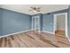 Bedroom features wood-look floors, blue accent wall, ceiling fan, and sliding mirrored closet doors at 4756 Fiske Cir, Orlando, FL 32826