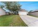 Home exterior with large driveway, lawn, and two-car garage at 4756 Fiske Cir, Orlando, FL 32826