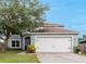 Charming two-story home featuring a two-car garage, well-maintained lawn, and mature trees at 4756 Fiske Cir, Orlando, FL 32826