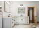 Bright bathroom boasts double vanities with marble countertops, black hardware, and modern mirrors and light fixtures at 4770 Drummond Ln, Orlando, FL 32810