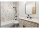 Bright bathroom boasts a combination tub and shower, white vanity, marble-style tile, and matte black fixtures at 4770 Drummond Ln, Orlando, FL 32810