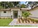 Detailed view of the front entrance showcasing lush plants, a brick pathway, and a modern aesthetic at 4770 Drummond Ln, Orlando, FL 32810