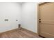 Bright laundry room with hardwood floors, hookups, and a doorway at 4770 Drummond Ln, Orlando, FL 32810