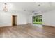Bright living room with wood-look flooring, a modern ceiling fan, and sliding glass doors that lead to the backyard at 4770 Drummond Ln, Orlando, FL 32810