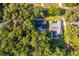 An aerial view shows a backyard with a pool surrounded by lush greenery and houses at 493 Princewood Dr, Deland, FL 32724