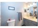 Simple bathroom featuring gray vanity and toilet, complemented by essential fixtures for functionality at 493 Princewood Dr, Deland, FL 32724