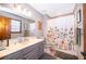 Neutral bathroom featuring a gray vanity, a floral shower curtain, and a large mirror for a clean and modern look at 493 Princewood Dr, Deland, FL 32724