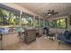 Relaxing screened porch with outdoor kitchen featuring a grill and ceiling fan at 493 Princewood Dr, Deland, FL 32724