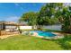Lush backyard offers a sparkling pool, lounge chairs, a deck, and mature landscaping for outdoor enjoyment at 4963 Hoperita St, Orlando, FL 32812