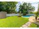Spacious backyard featuring a well-maintained lawn, a refreshing pool, and a privacy fence at 4963 Hoperita St, Orlando, FL 32812