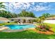 Inviting backyard with a sparkling pool, lush greenery, and a cozy lounge area perfect for relaxation at 4963 Hoperita St, Orlando, FL 32812