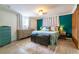 Bedroom with decorative accent wall, stylish dresser, rug and a cozy bed with decorative pillows and side tables at 4963 Hoperita St, Orlando, FL 32812