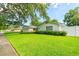 Well-maintained home showcasing a lush green lawn and neat landscaping, complemented by a white picket fence at 4963 Hoperita St, Orlando, FL 32812