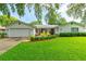 Charming single-story home featuring a well-manicured lawn and inviting front patio with lush landscaping at 4963 Hoperita St, Orlando, FL 32812