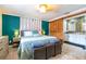 Main bedroom with accent wall, storage trunks, and wooden sliding door to the bath and closet area at 4963 Hoperita St, Orlando, FL 32812