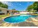 Beautiful backyard featuring a sparkling blue pool, a deck, and well-manicured landscaping at 4963 Hoperita St, Orlando, FL 32812