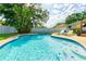 Inviting pool with lounge chairs, steps and lush landscaping provides a serene backyard retreat at 4963 Hoperita St, Orlando, FL 32812