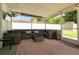 Screened lanai featuring ample seating, an outdoor fan, and views of the backyard with a privacy fence at 4963 Hoperita St, Orlando, FL 32812