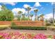 Community entrance featuring brick signage, lush landscaping, and vibrant flowerbeds at 5241 Vista Club Run, Sanford, FL 32771