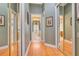 Hallway with hardwood floors, mirrored closet doors and bathroom view at 5241 Vista Club Run, Sanford, FL 32771