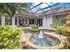 Stunning screened-in pool with a relaxing water fountain, rock features, and lush landscaping at 5241 Vista Club Run, Sanford, FL 32771