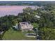 Stunning aerial view of a lakeside home with solar panels, mature trees, and a circular driveway at 5351 Carson St, St Cloud, FL 34771