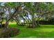 A sprawling green lawn is framed by mature trees, creating a peaceful and private backyard setting at 5351 Carson St, St Cloud, FL 34771