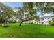 Expansive backyard featuring a large grassy area, mature trees, and an inviting patio for outdoor enjoyment at 5351 Carson St, St Cloud, FL 34771