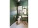 Stylish powder room featuring olive-green shiplap, gold accents, and patterned tile floors at 5351 Carson St, St Cloud, FL 34771