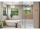 Luxurious bathroom featuring a standalone tub, glass shower, and modern chandelier at 5351 Carson St, St Cloud, FL 34771