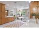 Bright bathroom featuring custom oak cabinetry, a freestanding tub, and a walk-in shower at 5351 Carson St, St Cloud, FL 34771