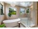 Bright and airy bathroom with a soaking tub, glass enclosed shower, and modern lighting at 5351 Carson St, St Cloud, FL 34771