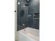 Modern bathroom featuring a tiled shower with rainfall showerhead, white tub, and niche at 5351 Carson St, St Cloud, FL 34771