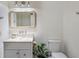 A charming, well-lit bathroom with a glass vessel sink, woven mirror, and white cabinets at 5351 Carson St, St Cloud, FL 34771