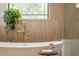 Close up of the free standing bathtub with decorative plant and gold fixtures at 5351 Carson St, St Cloud, FL 34771
