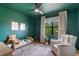 Cozy green bedroom with a unique color scheme, a large window, and comfortable seating area at 5351 Carson St, St Cloud, FL 34771