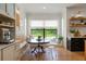 Bright breakfast nook with a large window, custom bench, and transparent chairs offering picturesque outdoor views at 5351 Carson St, St Cloud, FL 34771