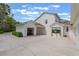 Exterior view of the home featuring an attached garage, lush landscaping, and a spacious driveway, all on a sunny day at 5351 Carson St, St Cloud, FL 34771