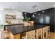 Close-up of a kitchen island with a black countertop, seating for four, and stylish pendant lighting at 5351 Carson St, St Cloud, FL 34771